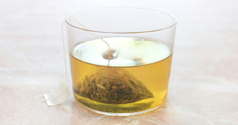 Glas mit frisch aufgebrühtem Tee und Teebeutel