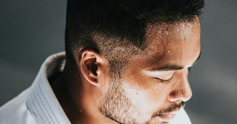 Schweißperlen auf der Stirn eines Mannes, Nahaufnahme