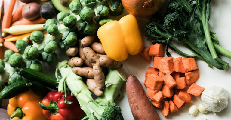 Verschiedenes frisches Obst und Gemüse, darunter Paprika, Süßkartoffeln, Brokkoli und Rosenkohl