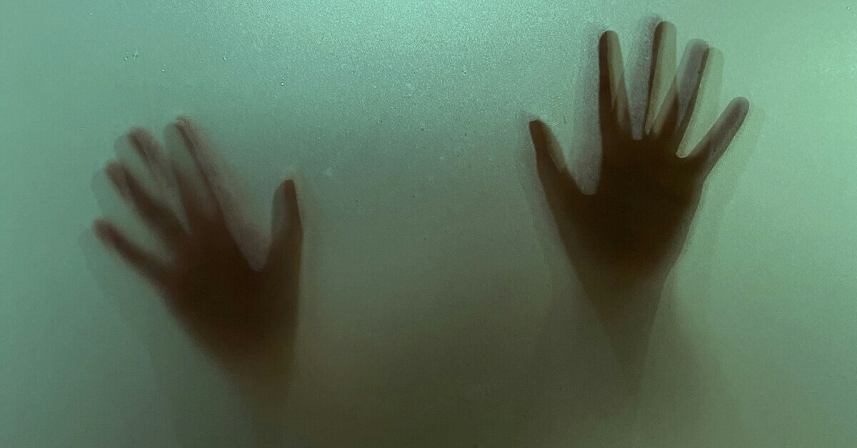 Schemenhafte Hände hinter einer matten Glasfläche