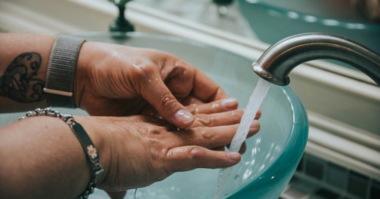 Hände waschen unter fließendem Wasser am Waschbecken