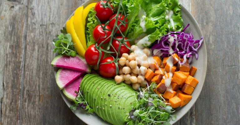 Gesunde Ernährung mit frischem Gemüse und Avocado – ausgewogene Ernährung Bunte gesunde Ernährung mit frischem Gemüse, Kichererbsen, Avocado und Salat in einer Schüssel