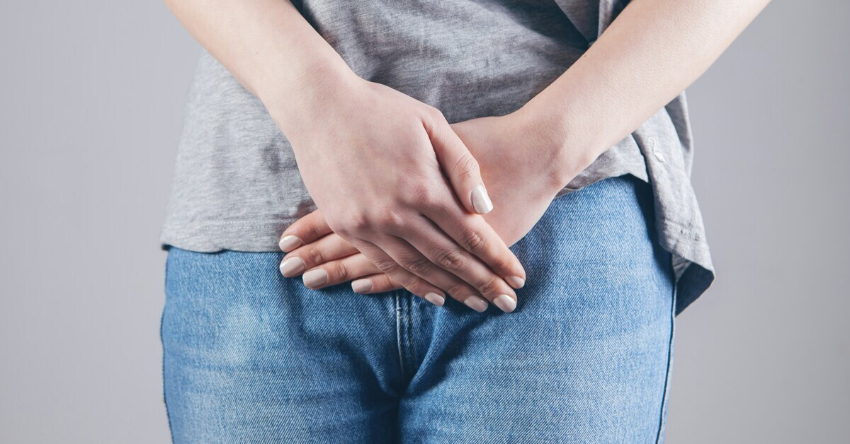 Frau hält sich den Unterbauch bei Blasenentzündung