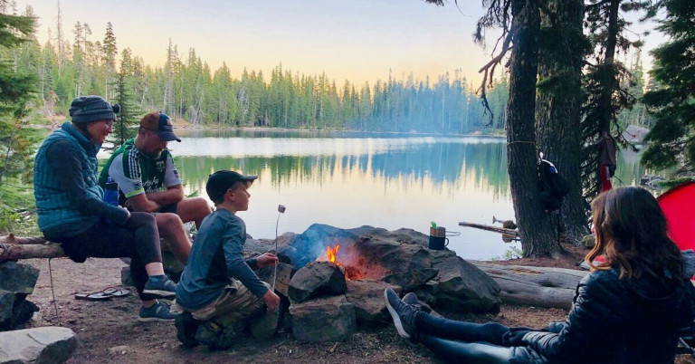 Familiencampen am See mit Lagerfeuer und Marshmallow-Grillen in der Natur