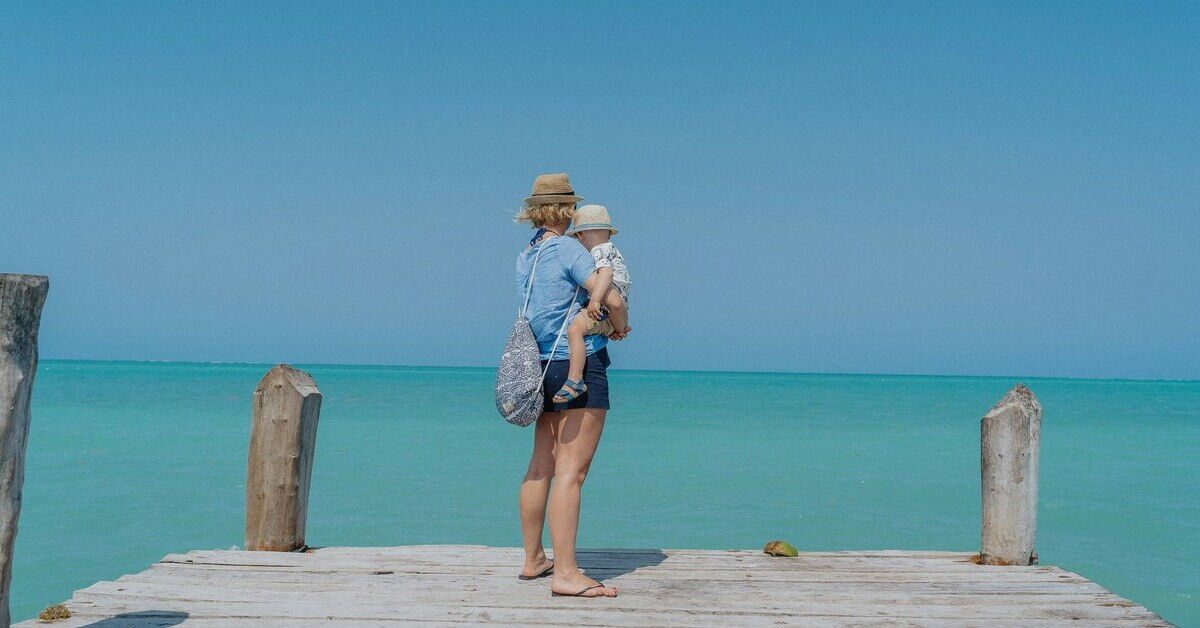 Frau reist mit Kind am Meer – Reisen mit Kind, Urlaub am Wasser