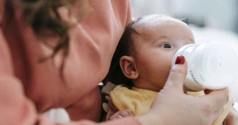 Kind futtern – Baby wird mit der Flasche gefüttert Baby wird von einer Frau mit der Flasche gefüttert – kind futtern