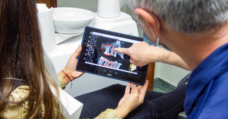 Zahnarzt-Beratung mit digitaler Röntgenaufnahme auf Tablet