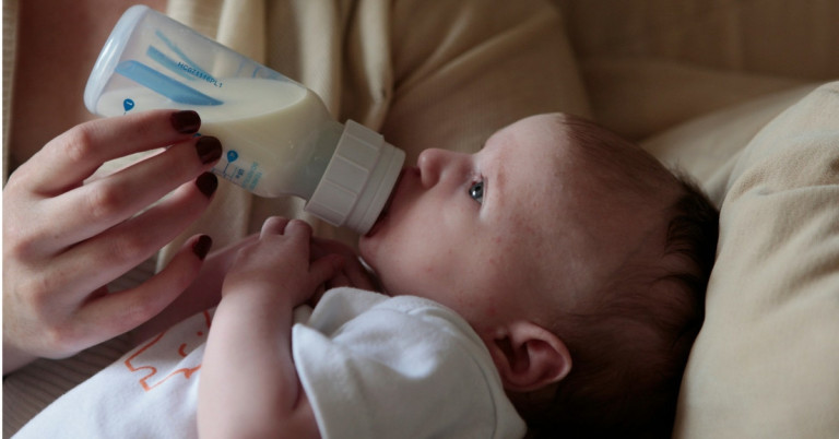Baby trinkt aus Fläschchen. Baby überhitzt – Fläschchen trinken zum abkühlen