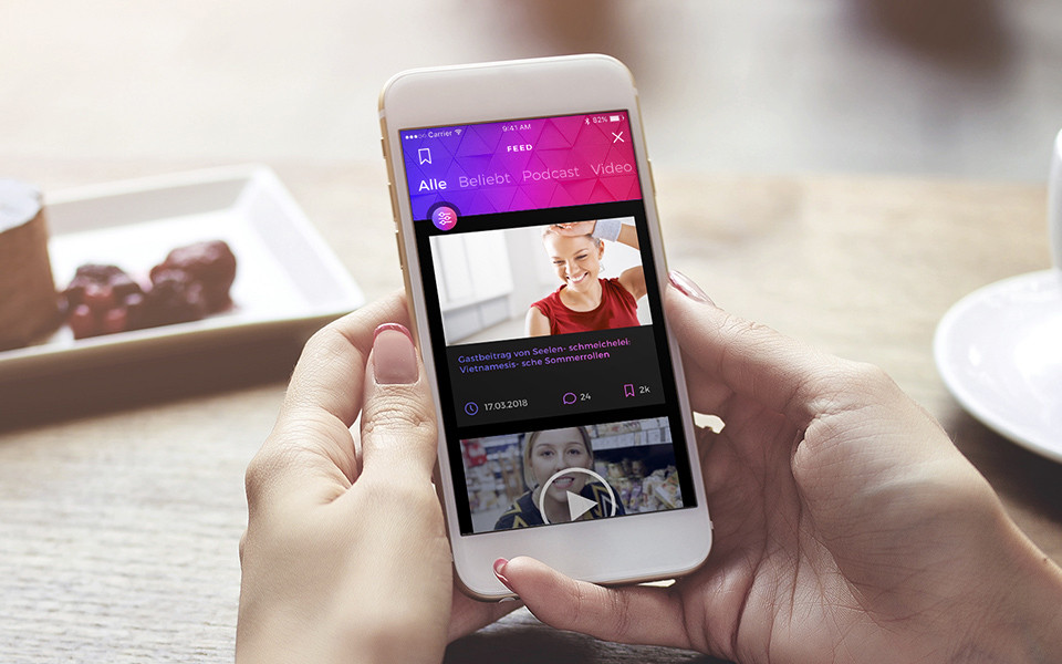 Person hält Smartphone mit geöffneter App in der Hand