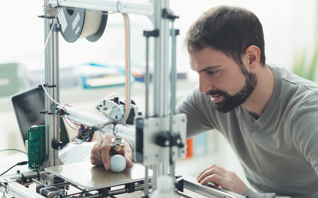Mann bei der Arbeit an einem 3D-Drucker in der Industrie