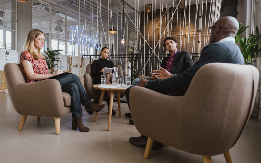Diskussion in einem modernen Büro mit vier Personen