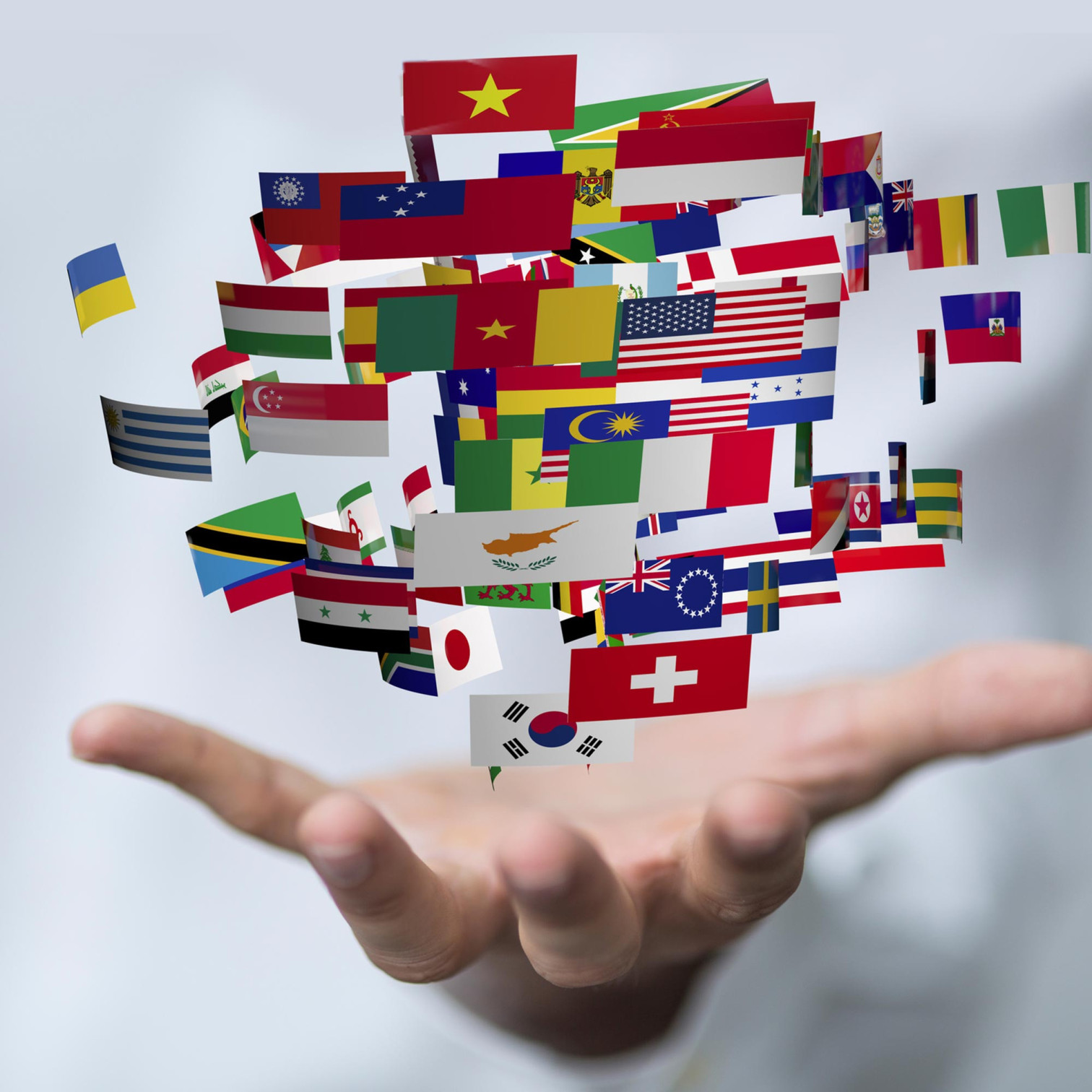 Hand hält schwebende Flaggen verschiedener Länder