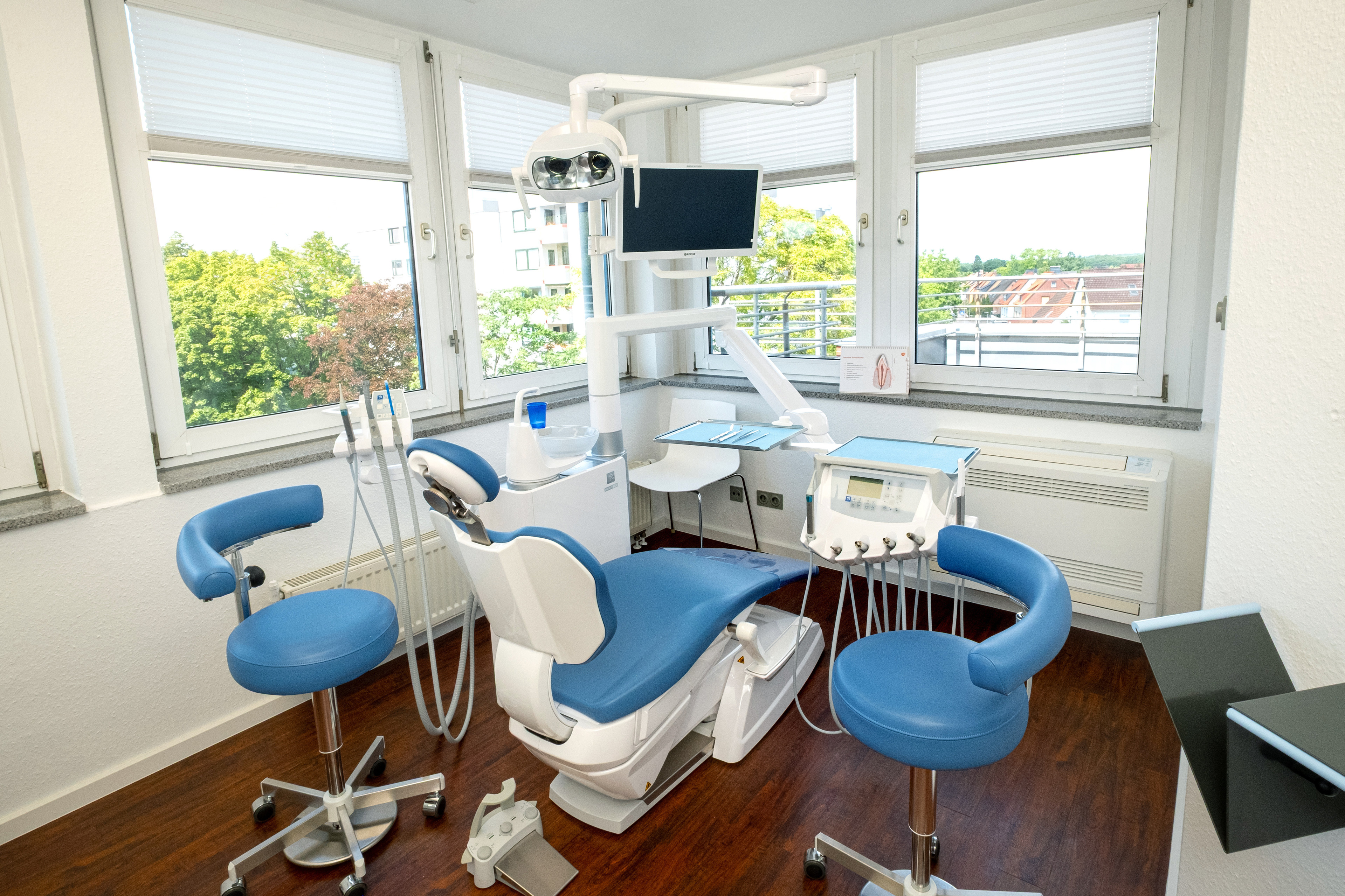 Behandlungszimmer ohne Zahnarzt im modernen Praxisraum mit Ausblick Modernes Behandlungszimmer ohne Zahnarztstuhlbesetzung in einer Zahnarztpraxis mit Blick nach draußen