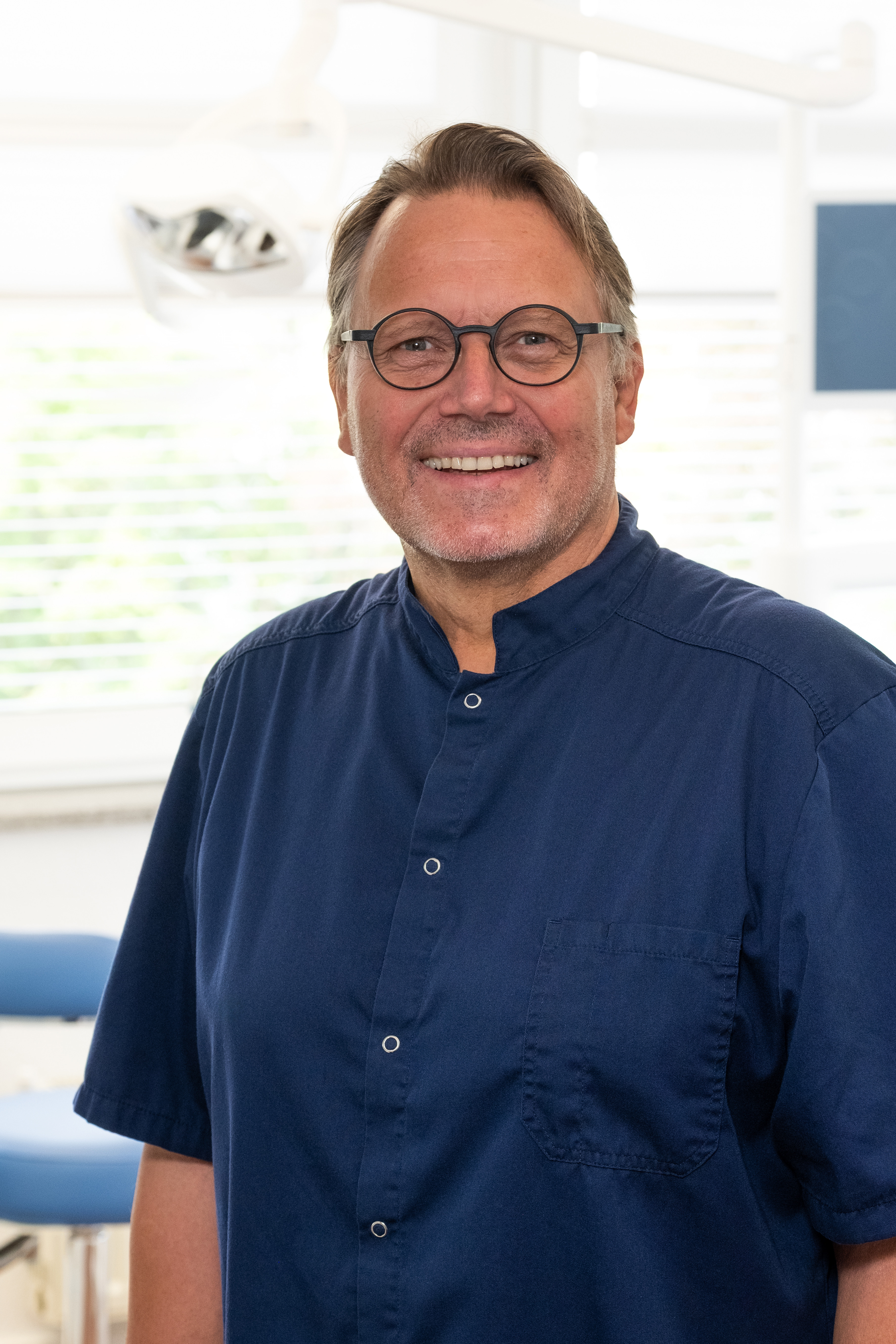 Gunter Lach in Praxisumgebung mit blauem Arztkittel Gunter Lach im blauen Arztkittel in einer Praxis