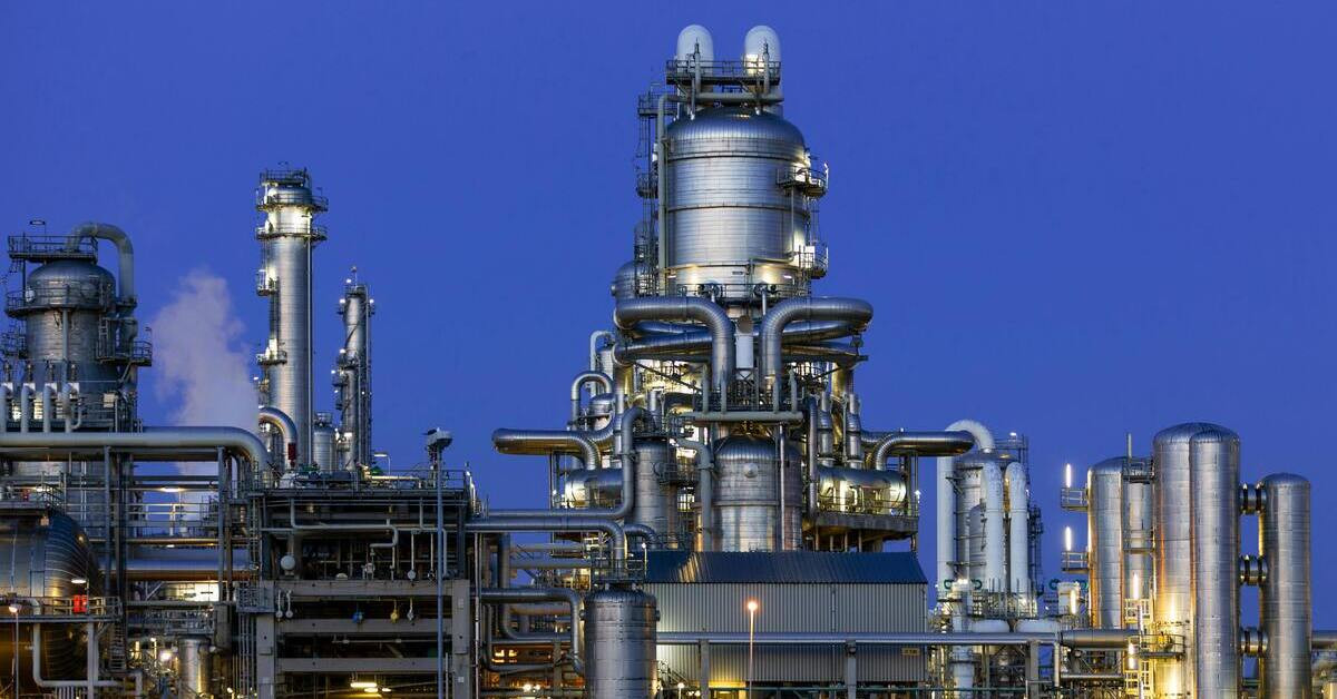 Moderne Raffinerie bei Nacht mit industriellen Anlagen und Rohrleitungen