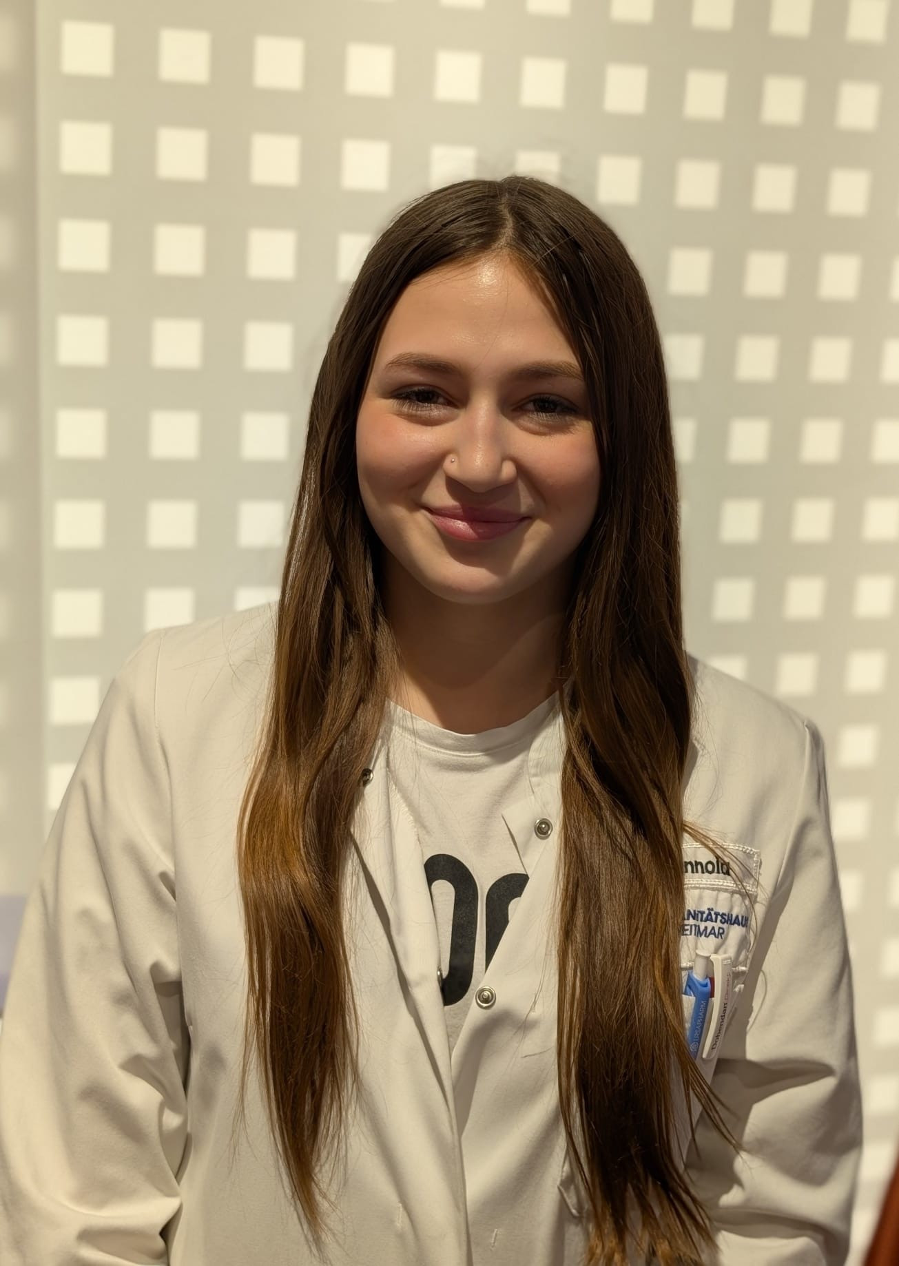 Emilie Mennoia als Auszubildende im Sanitätsfachhandel mit weißem Kittel