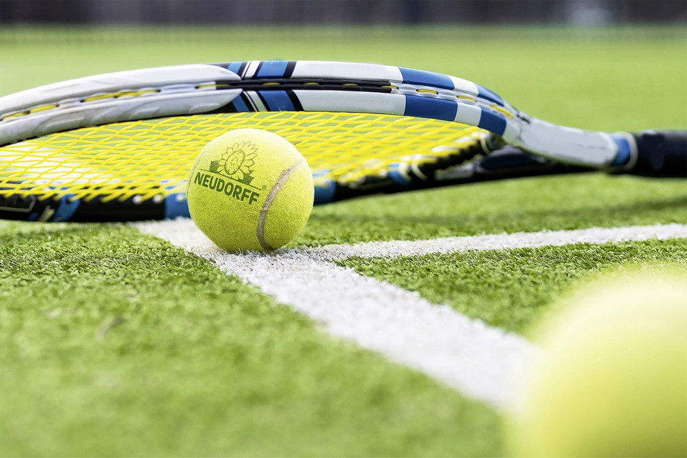 Neudorff Tennisball und Schläger auf dem Rasen der Terra Wortmann Open Neudorff Tennisball und Schläger bei den Terra Wortmann Open