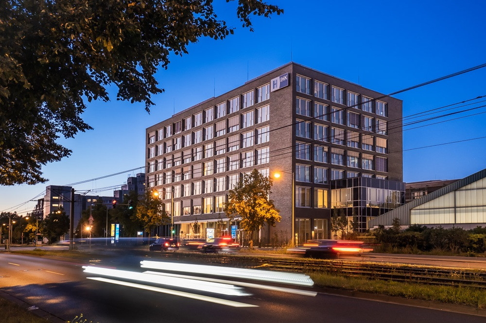IHK Neubau bei Abenddämmerung mit Verkehr Abendaufnahme des IHK Neubaus mit beleuchteten Fenstern und vorbeifahrenden Autos