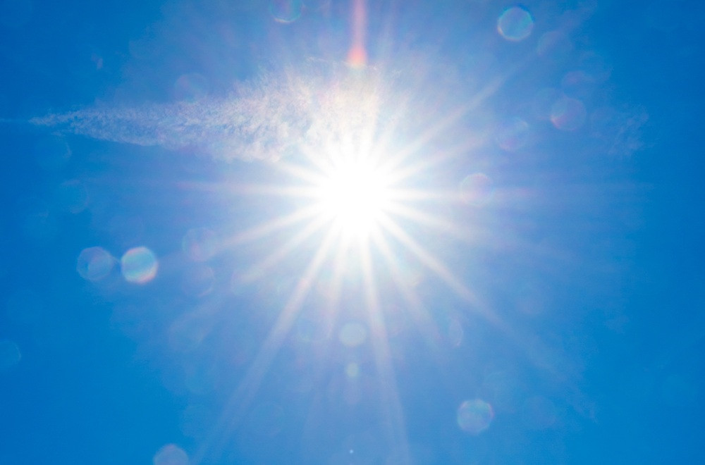 Heller Sonnenschein am blauen Himmel mit Sonnenstrahlen und leichter Wolke