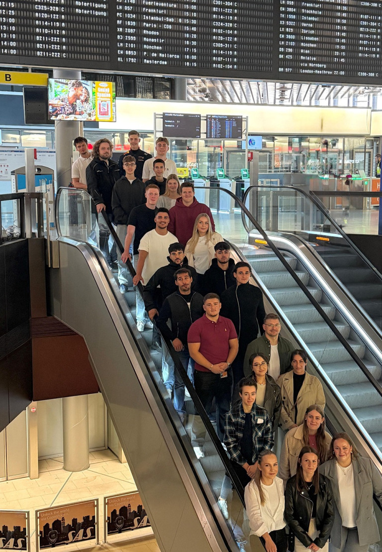 Gruppe von Auszubildenden beim Ausbildungsstart am Flughafen Hannover (HAJ) auf einer Rolltreppe