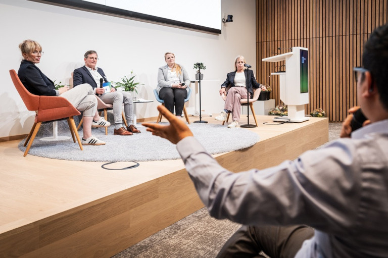 Podiumsdiskussion beim IHK Podcast am 25.06.2025 mit mehreren Teilnehmern auf moderner Bühne