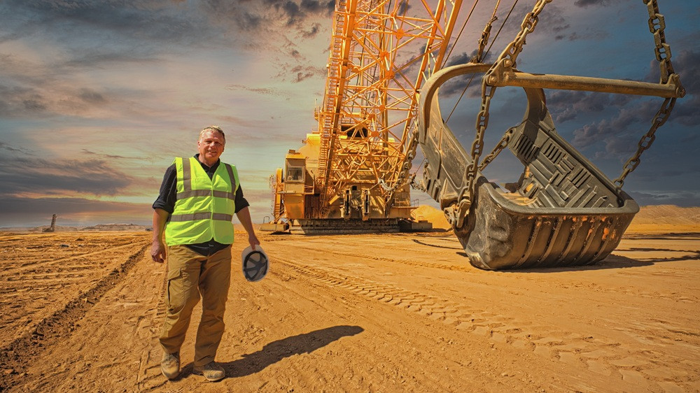 Baustelle in Jordanien im August mit großem Bagger und Bauarbeiter