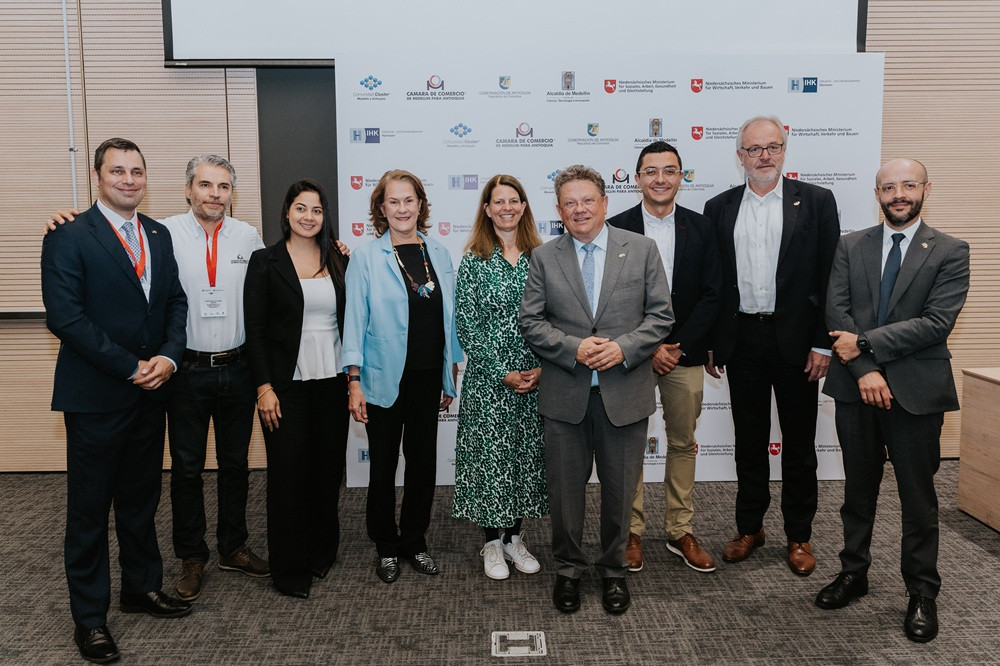 Adelante Colombia: Gruppenbild von Teilnehmern auf der Veranstaltung Gruppenfoto bei der Veranstaltung Adelante Colombia mit Teilnehmern vor Sponsorenwand