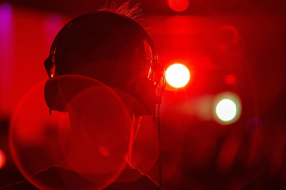 Person mit Kopfhörern – Musik, DJ oder Party im roten Licht Person mit Kopfhörern in rotem Licht, Musikgenuss oder DJ-Atmosphäre