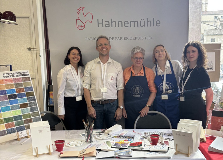 Hahnemühle Messestand – Team und hochwertige Papierprodukte auf einer Messe Hahnemühle Messestand mit Team und Papierprodukten auf einer Messe