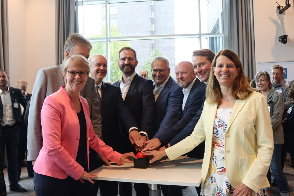 Gruppe drückt Buzzer bei Event – gemeinsamer Start oder symbolischer Moment Gruppe von Personen drückt gemeinsam auf einen roten Buzzer bei einer Veranstaltung