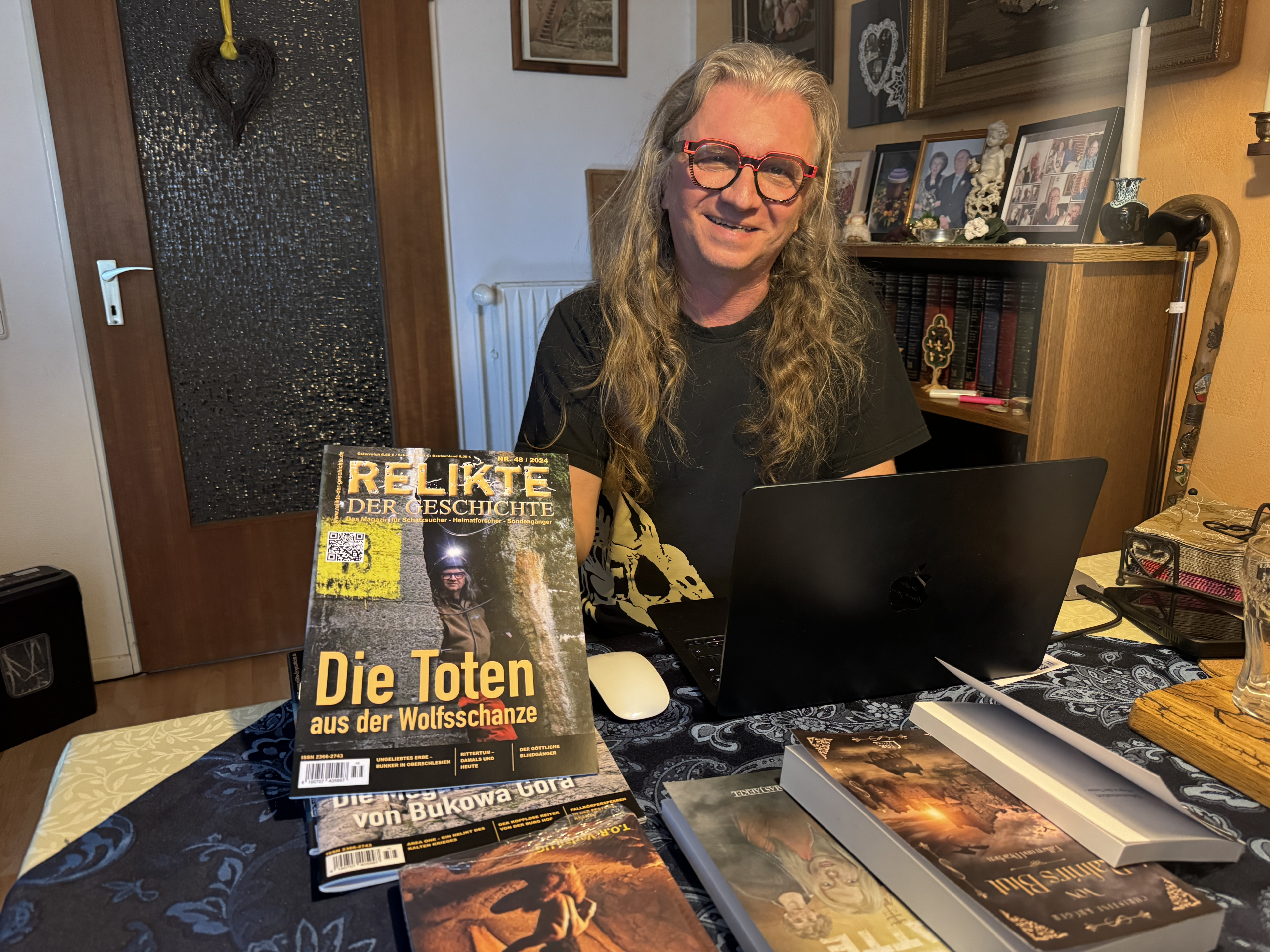 Person am Schreibtisch mit Zeitschrift 'Relikte der Geschichte' und Titel 'Die Toten aus der Wolfsschanze'