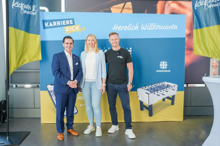 Karriere Kick Begrüßung mit BundeswehrLogo und Willkommensbanner Begrüßung beim Karriere Kick Event mit Bundeswehr-Logo, drei Personen vor Willkommensbanner