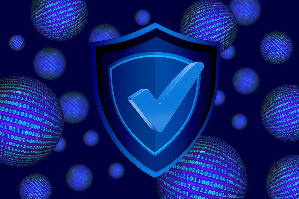 Blaues Schild mit Häkchen – Symbol für Datenschutz und IT-Sicherheit Blaues Schild mit Häkchen als Symbol für Datenschutz und IT-Sicherheit vor digitalen Binär-Code-Kugeln