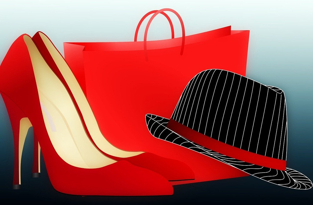Rote High Heels, Hut und Einkaufstasche – stilvolle Mode-Accessoires Rote High Heels, ein rot-schwarzer Hut und eine rote Einkaufstasche als Mode-Accessoires