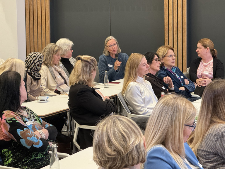Frauenrunde bei einer Konferenz oder einem Seminar, Teilnehmerinnen diskutieren in einem modernen Konferenzraum
