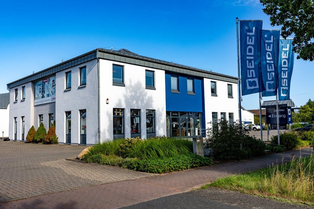 Außenansicht der Seidel Textilreinigung mit Firmengebäude und Seidel-Flagge