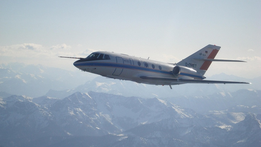 Falcon 20E im Flug über verschneiten Bergen