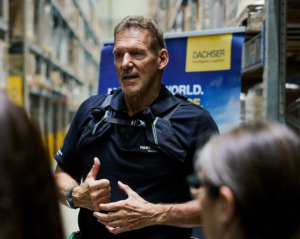 Ralf Moeller mit Ottobock-Exoskelett bei DACHSER im Lager