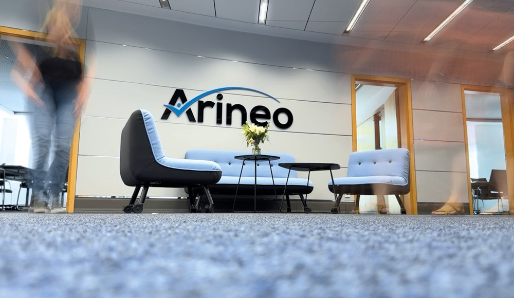 Empfangsbereich der Arineo GmbH mit modernen Sitzmöbeln und Firmenlogo an der Wand