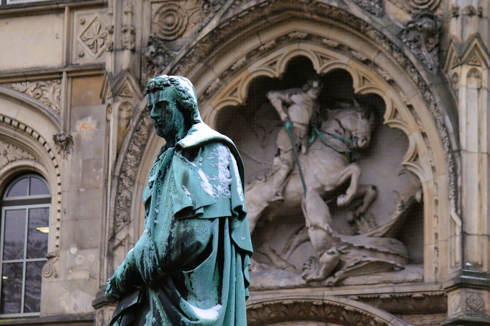 Schiller-Denkmal an der Georgstraße mit Relief im Hintergrund