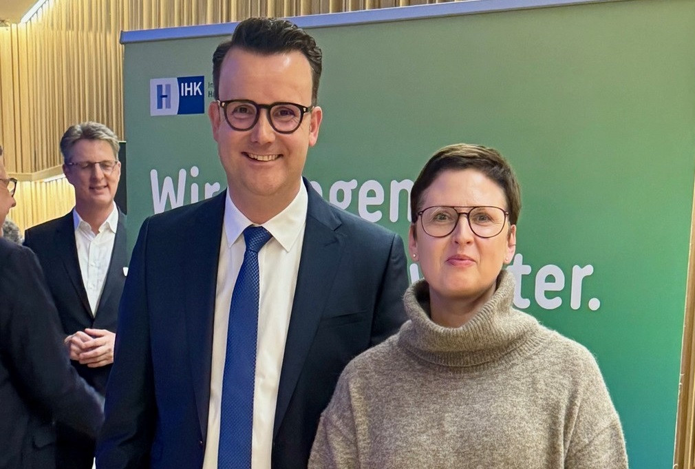 Zwei Personen vor einem IHK Banner bei einer Veranstaltung