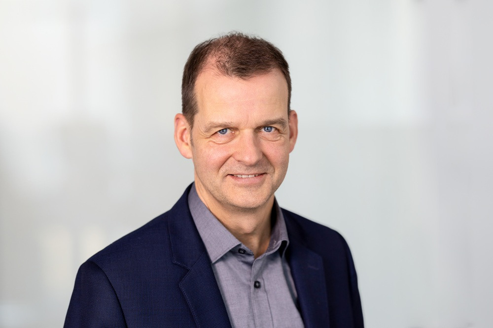 Tilman Brunner im Business-Outfit vor hellem Hintergrund