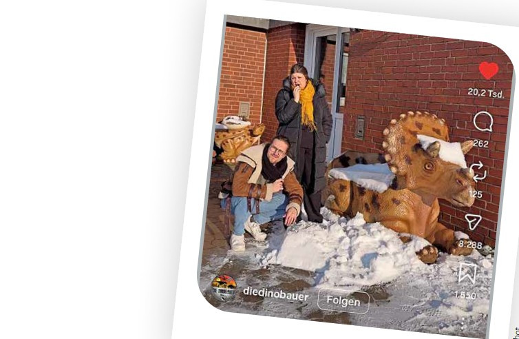Screenshot von diedinobauer mit Dinosaurier-Skulptur im Schnee vor Backsteingebäude