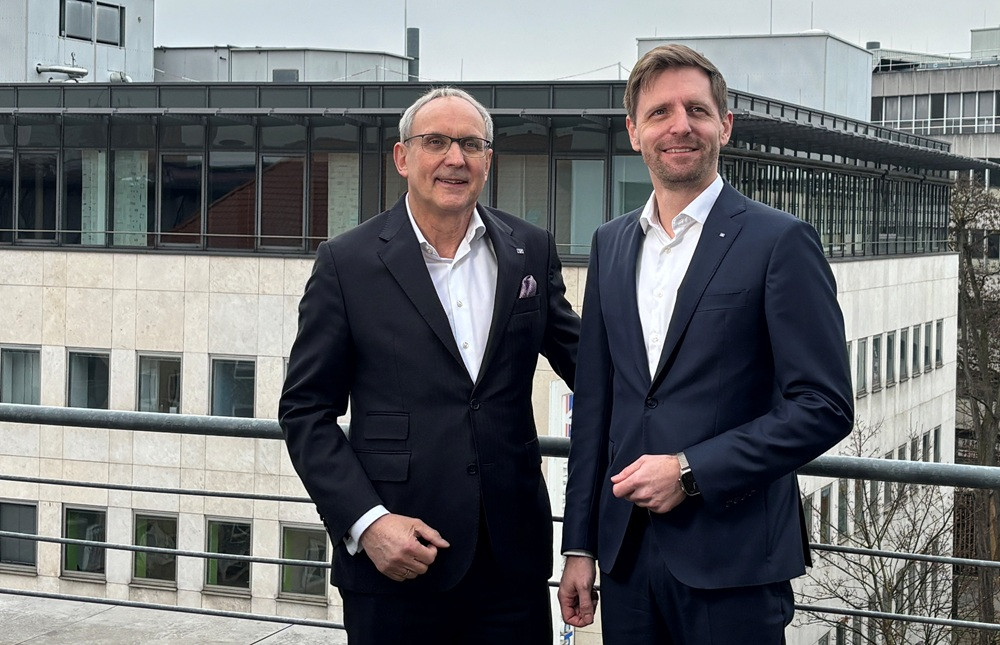 Zwei Männer im Anzug vor dem Gebäude der Volksbank