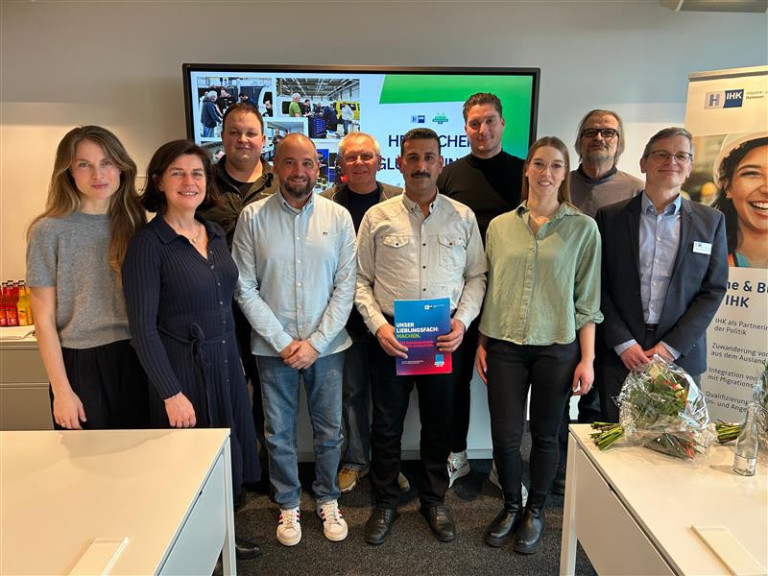 Gruppenfoto bei der Validierung mit Alan Abdulla, Teilnehmer halten Zertifikat vor einem Bildschirm