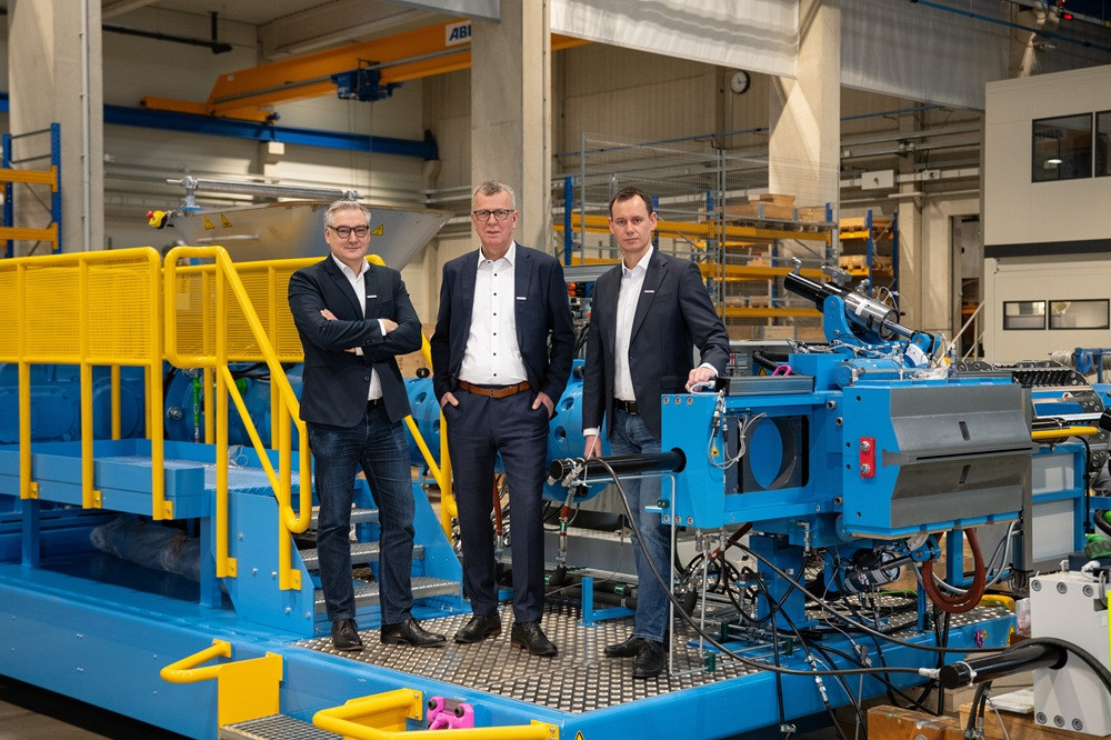 Geschäftsführung von Troester vor Maschinenanlage in industrieller Produktionshalle