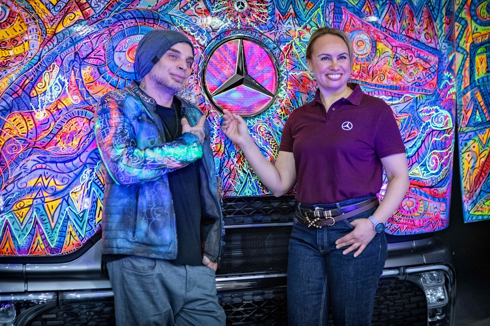 Kunst auf LKW mit buntem Mercedes-Benz Design und zwei Personen vor dem Fahrzeug