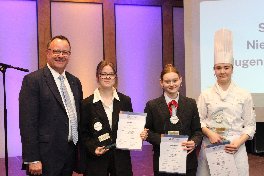 Siegerinnen und Sieger der DEHOGA Jugendmeisterschaften mit Urkunden und Pokalen auf der Bühne