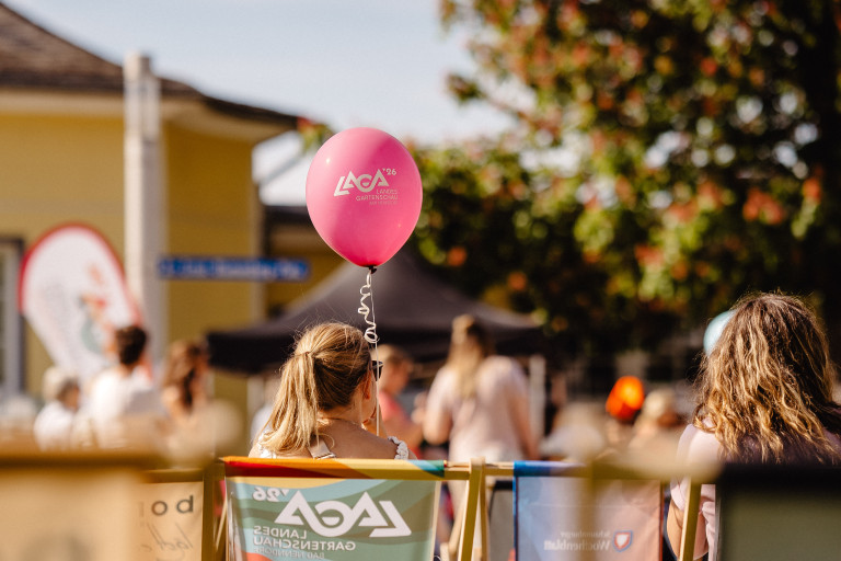 Vorfreude auf die Landesgartenschau – Marie Christin Pratsch mit Luftballon Marie Christin Pratsch bei der Landesgartenschau mit einem pinken Luftballon und sommerlicher Stimmung
