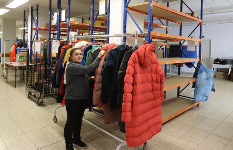 Frau beim Aufhängen der gereinigten und imprägnierten Kleidungsstücke.